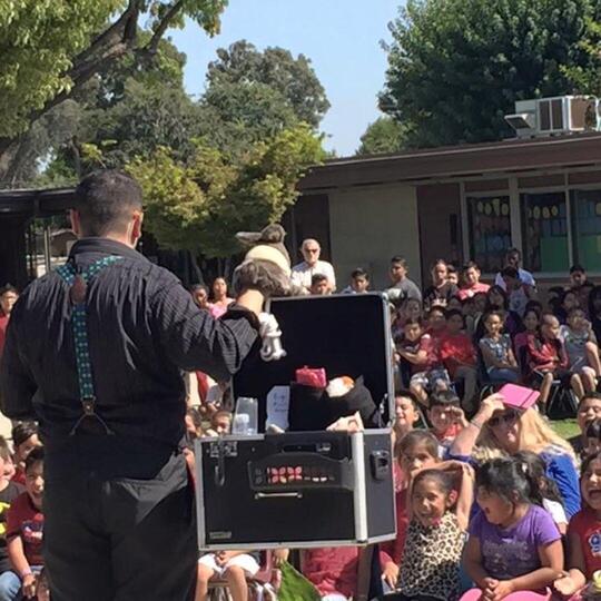 Wacko performing a puppet show for a school assembly
