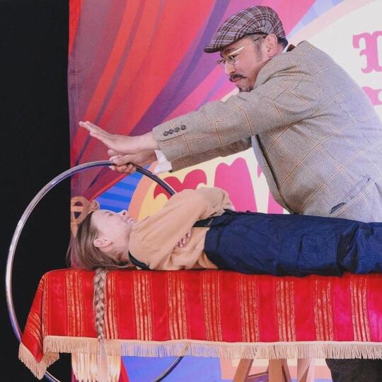 Wacko performing a classic magic trick with a floating ring and a child volunteer